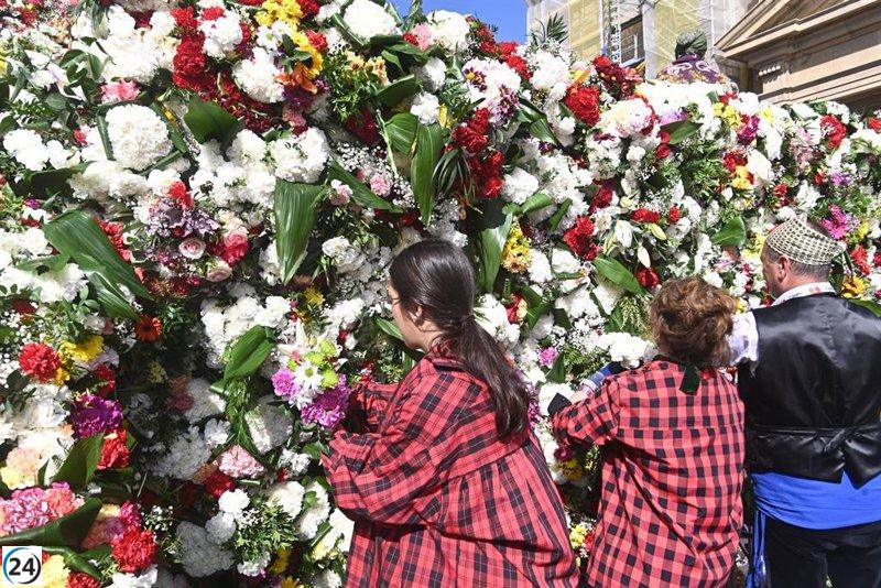 Vibrante celebración con ofrenda floral a la Virgen del Pilar en un día soleado.